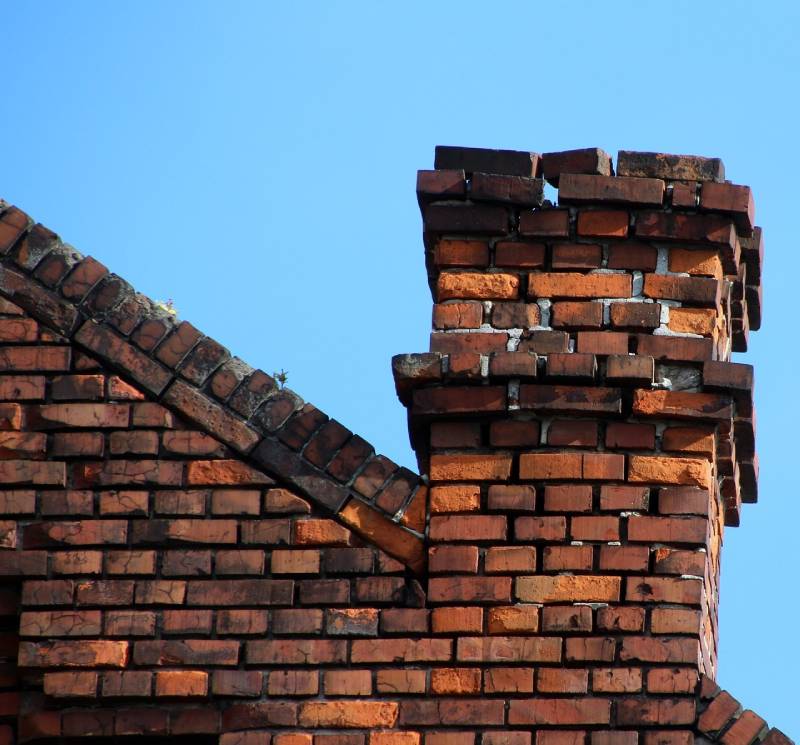 Damaged chimney on an Edgemere home showing cracks and missing mortar